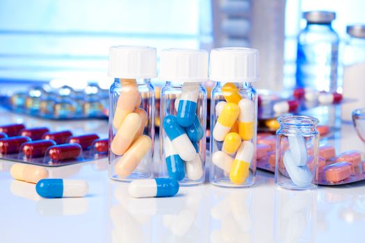 Colorful medical capsules in bottle, on white background.