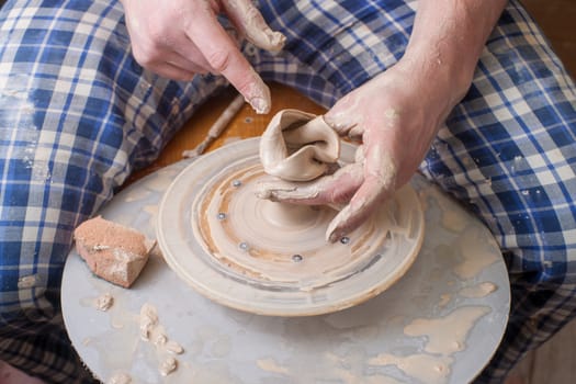 Hands of a potter, creating an earthen jar on the circle