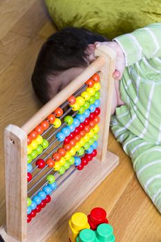 Funny education, baby playing with wooden abacus