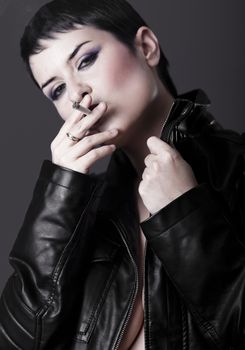 Nude woman with black leather jacket smoking a cigarette