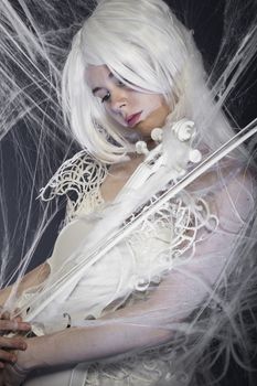 beautiful woman with couture gown in white, violin, music concept