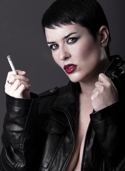 Naked woman with black leather jacket smoking a cigarette