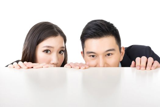 Asian business man and woman hide under the table and looking somewhere.