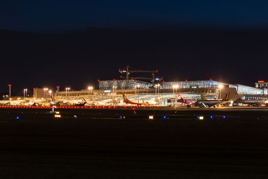 STUTTGART, GERMANY - MAY 6, 2014: Stuttgart Airport at dusk with planes departing and arriving as seen from over the fields on May, 6, 2014 in Stuttgart, Germany. Stuttgart Airport is the 6th biggest airport in Germany, having a capacity of 14 million people per year.