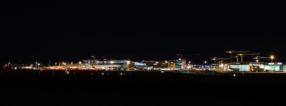 STUTTGART, GERMANY - MAY 6, 2014: Wide angle shot of Stuttgart Airport at dusk with planes departing and arriving as seen from over the fields on May, 6, 2014 in Stuttgart, Germany. Stuttgart Airport is the 6th biggest airport in Germany, having a capacity of 14 million people per year.