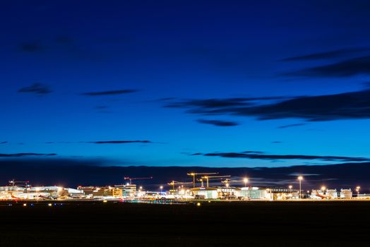 STUTTGART, GERMANY - MAY 6, 2014: Wide angle shot of Stuttgart Airport at dusk with planes departing and arriving as seen from over the fields on May, 6, 2014 in Stuttgart, Germany. Stuttgart Airport is the 6th biggest airport in Germany, having a capacity of 14 million people per year.