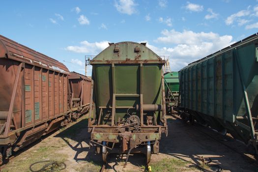 Multiple old industrial train wagons on rail tracks