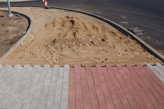 A light gray and red patterned unfinished sidewalk construction site