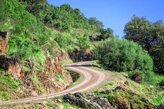 Winding Road in the Mountain, blue on sky background