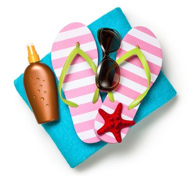 Beach accessories. Flip-flops, towel, sun tan lotion and sunglasses on white background. Top view