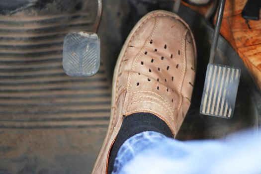 Mans feet pushing on the accelerator of automobile