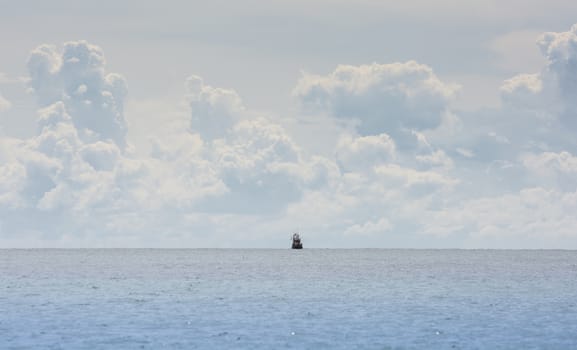 Fishing boat at the coast of Thailand on cloud background