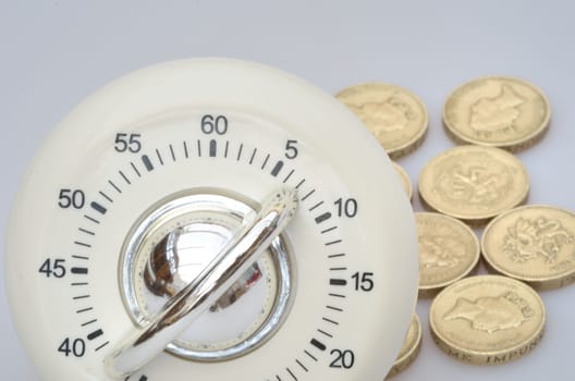 Timer in close up with group of pound  coins