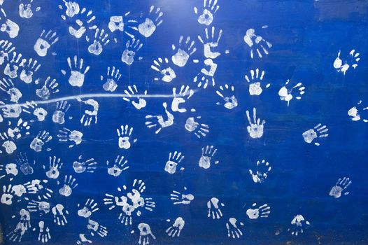 white handprints on a blue wall
