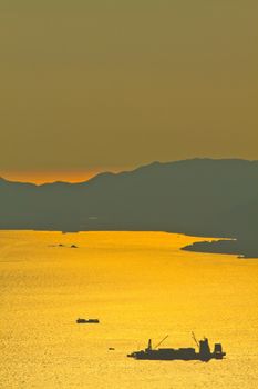 Bulk-carrier ship at sunset in the sea