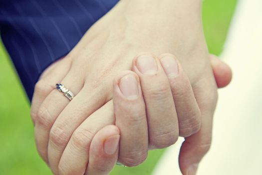 Couple holding hands with wedding ring