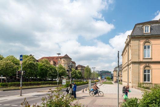 STUTTGART, GERMANY - APRIL 26, 2014: People are passing the city center of Stuttgart with the old (left) and new castle (right) and the new art museum in the middle on April, 26, 2014 in Stuttgart, Germany. The old castle with the new one next to it count as one of the largest tourists attractions of Stuttgart since it is located right in the very center of the city.