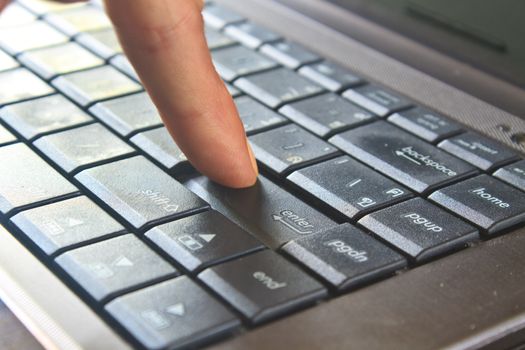 close up finger pushing the button of keyboard