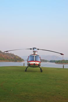 helicopter standing on landing strip in airfield near lake in morning
