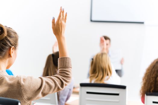 image of a female hand raised in university classroom