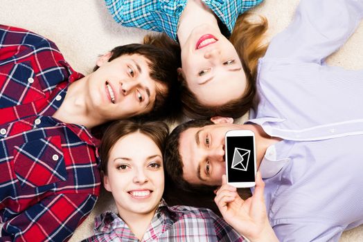 four young people are together, the young man pressed his lips to the phone