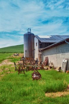 Agricultural tools and silos under blue sky in a farm