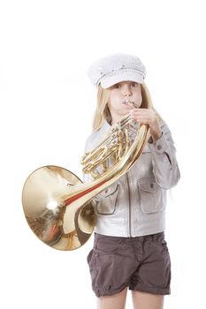 young girl with cap playing french horn against white background