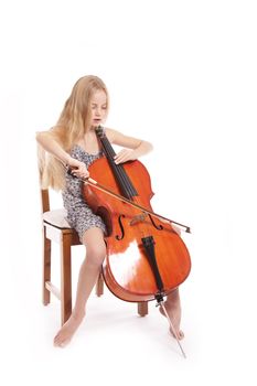 young girl in dress playing cello against white backgound