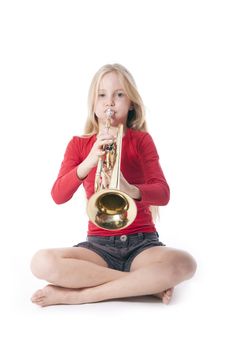 young girl in red playing trumpet against white backgound
