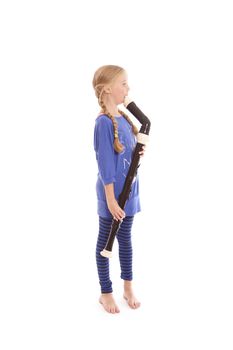 young girl in blue playing bass recorder against white backgound