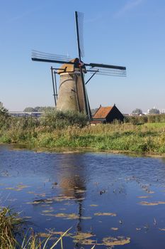 White windmill and house near river in Holland