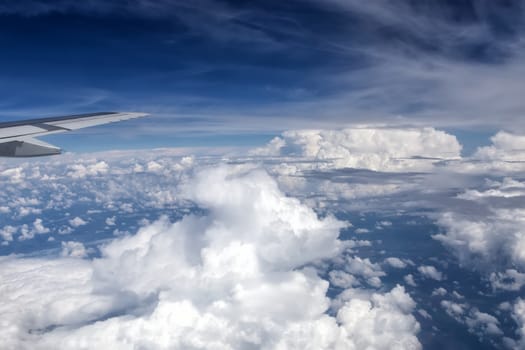 View over the clouds from the window of the plane