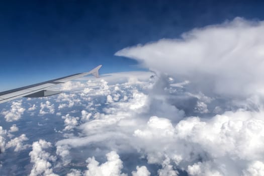 View over the clouds from the window of the plane