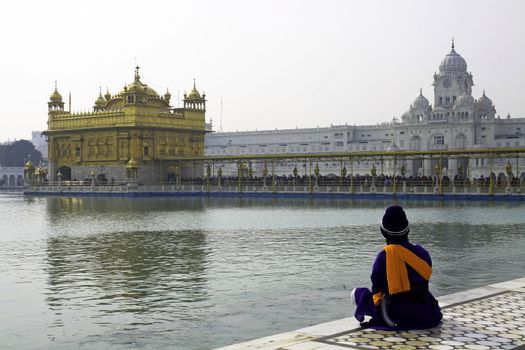 The Golden Temple at Amritsar in Punjab, India is always peaceful and tranquil. I found this young sikh man sitting in deep contemplation unmindful of the crowds nearby. his indigo dress and turban stand out at once from the muted colors around him and his kirpan adds to the mystery.

