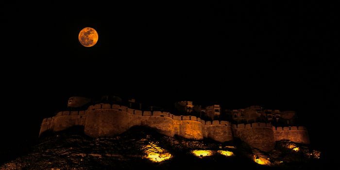 Jaisalmer Fort in the Deserts of Rajasthan in India is rightly called "The golden Fort". The Full moon over the Fort illuminated my sodium vapor lights presents a stunning panorama