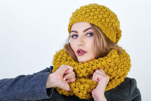 Young attractive Frenchwoman in knitted hat and scarf isolated on white background
