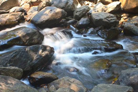 waterfall and rocks covered with moss in deep forest