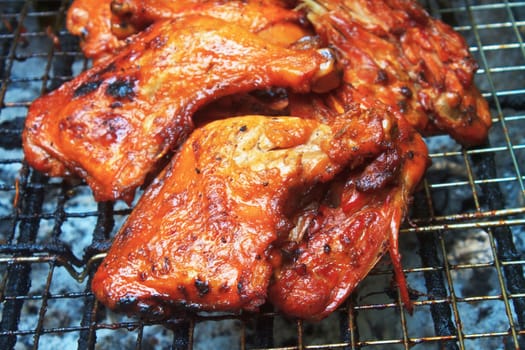 Grilled chicken thigh on the flaming grill 
