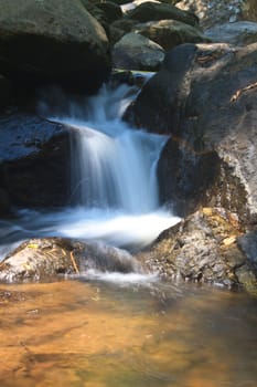 waterfall and rocks covered with moss in deep forest