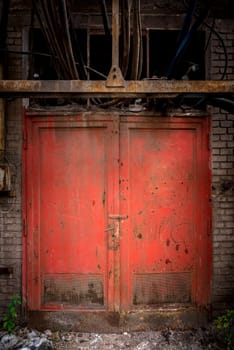 Gray steel wall with the red steel door