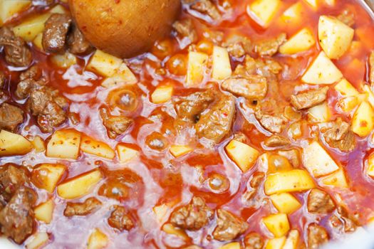 Prepare of hungarian soup goulash in the boiler. Closeup