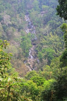 waterfall and rocks covered with moss in deep forest