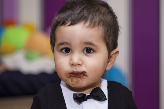 Happy, Adorable happy baby eating chocolate, wearing suit and bow tie