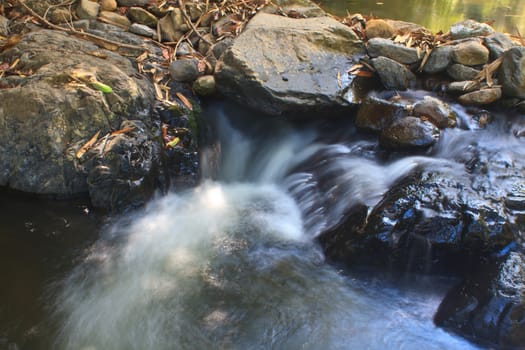 waterfall and rocks covered with moss in deep forest