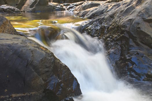 waterfall and rocks covered with moss in deep forest