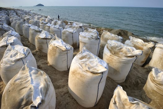 Sand bags along the beach in Songkra to protect from heavy surf and erosion, Thailand.