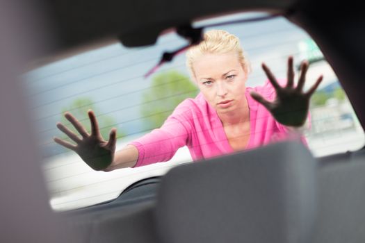 Self-sufficient, strong, young woman pushing a car. Engine breakdown.