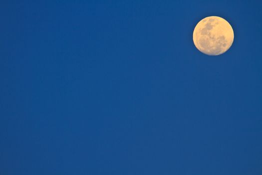 full moon in dark sky during the day