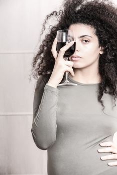 A young brazilian woman with a glass of red wine.