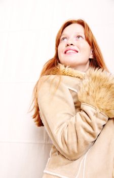 A attractive young, redhead woman in Winter clothing.  